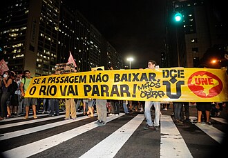 Rio de Janeiro koʻchasidagi namoyish. Plakatda „Se a passagem não baixar, o Rio vai parar!“ (oʻzbekcha: Chipta (narxi) tushmasa, Rio toʻxtaydi!) deb yozilgan.