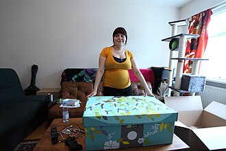 The maternity package, in neutral colors, is seen next to a mother expecting a baby.