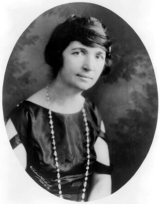 A head/shoulder portrait of an attractive woman, dressed in fashions from around 1920.