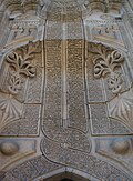 Kirish qismining naqshlar bilan nafis bezatilgan, toshdan ishlangan fasadi