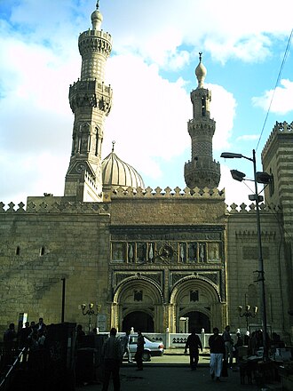 Ikki yoysimon kirish yo‘laklari bo‘lgan baland ikki qavatli bino ayvoni ko‘chaga qaragan. Yoylar ustidagi bino devori o‘ymakorlik va bezaklar bilan ishlangan. O‘ng tomonda bino uchinchi qavatgacha ko‘tarilgan. Devor ortida gumbaz ustidan ko‘tarilgan ikki minora ko‘rinib turibdi.
