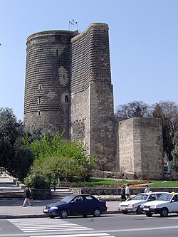 Large gray tower, with cars on an adjacent street