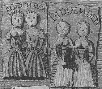 Two rectangular cakes, one showing two women apparently conjoined at the shoulder and the other one damaged in such a way that it is not clearly apparent whether the women are conjoined. Each cake has the word "Biddenden" written above the women.