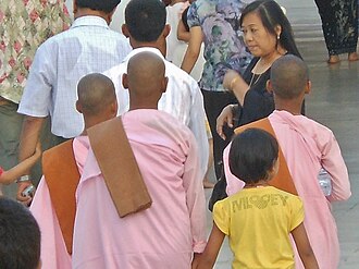 Birmaning Yangon shahrida pushti rang libosdagi uchta rohiba.