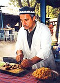 Erkak Tojikiston milliy taomi boʻlgan palov tayyorlaydi.
