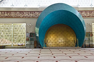 The interior of a modern mosque. The camera is focused on its mihrab.