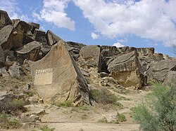 Rocky area, with a sign carved onto a rock